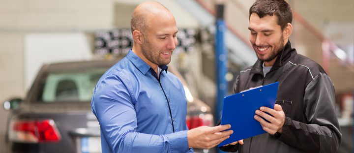 Two men reviewing information on a clipboard